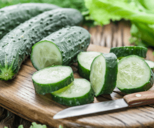 Fresh sliced cucumbers on a wooden surface.