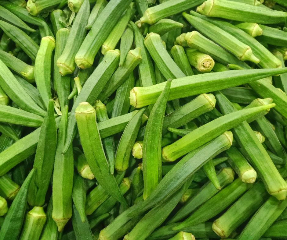 A bumper crop of delicious okra pods in a pile on a table.