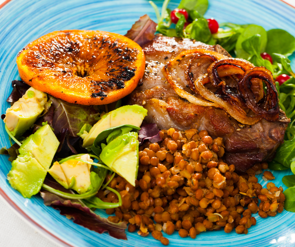 Puerto Rican Arroz con Gandules with pan fried pork chop, avocado, grilled orange and salad.