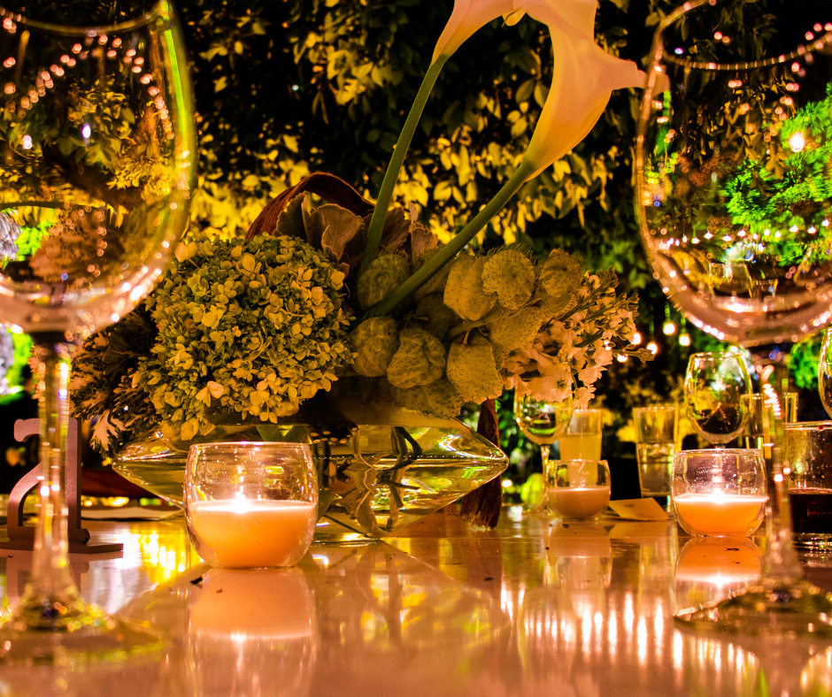 Candlelight and lush greenery on a romantic garden dinner table.