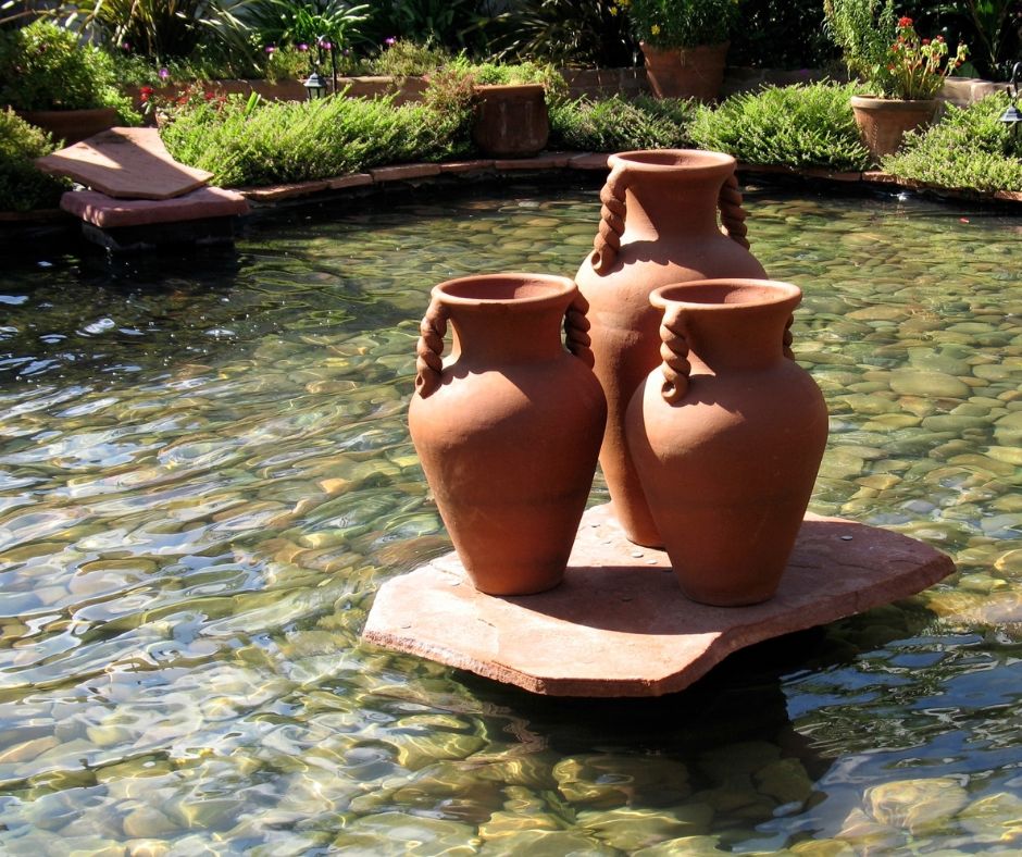 shallow backyard pond featuring a centerpiece of unique terracotta pots