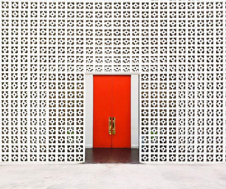 Breeze block entryway shielding front of home from street view only stunning red door visible