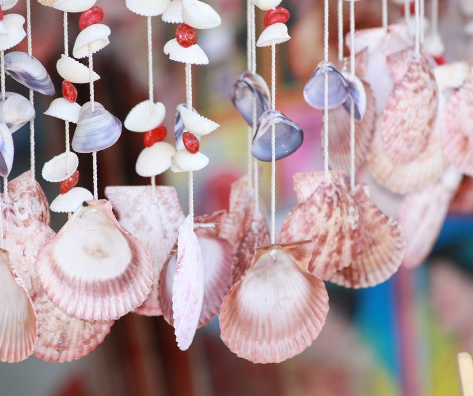 A colorful homemade seashell windchime made with beads and different sized shells.