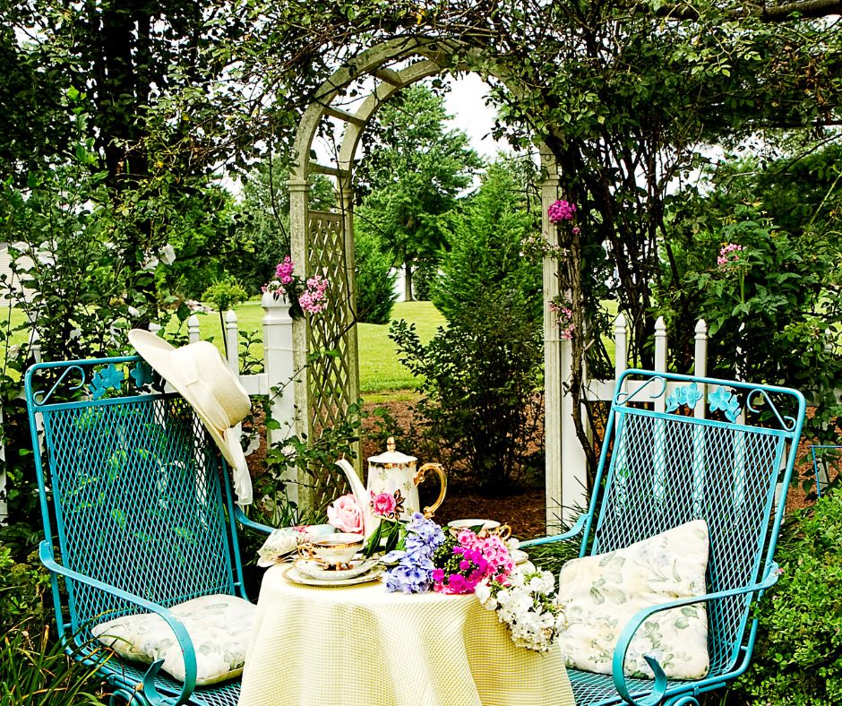 A romantic trellis idea for the garden. A sitting area for two with a arched trellis in background and a table set to serve tea.

