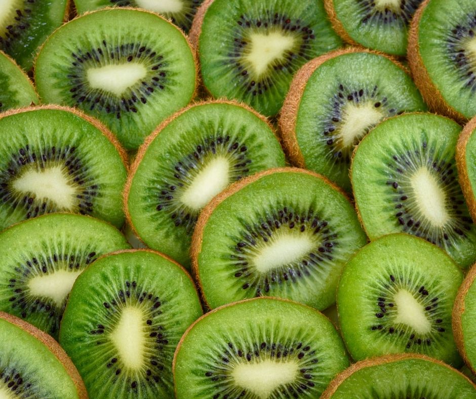 Slices of fresh kiwi with the fuzzy skin on.