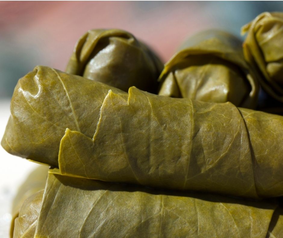 A stack of stuffed rolled grape leaves.