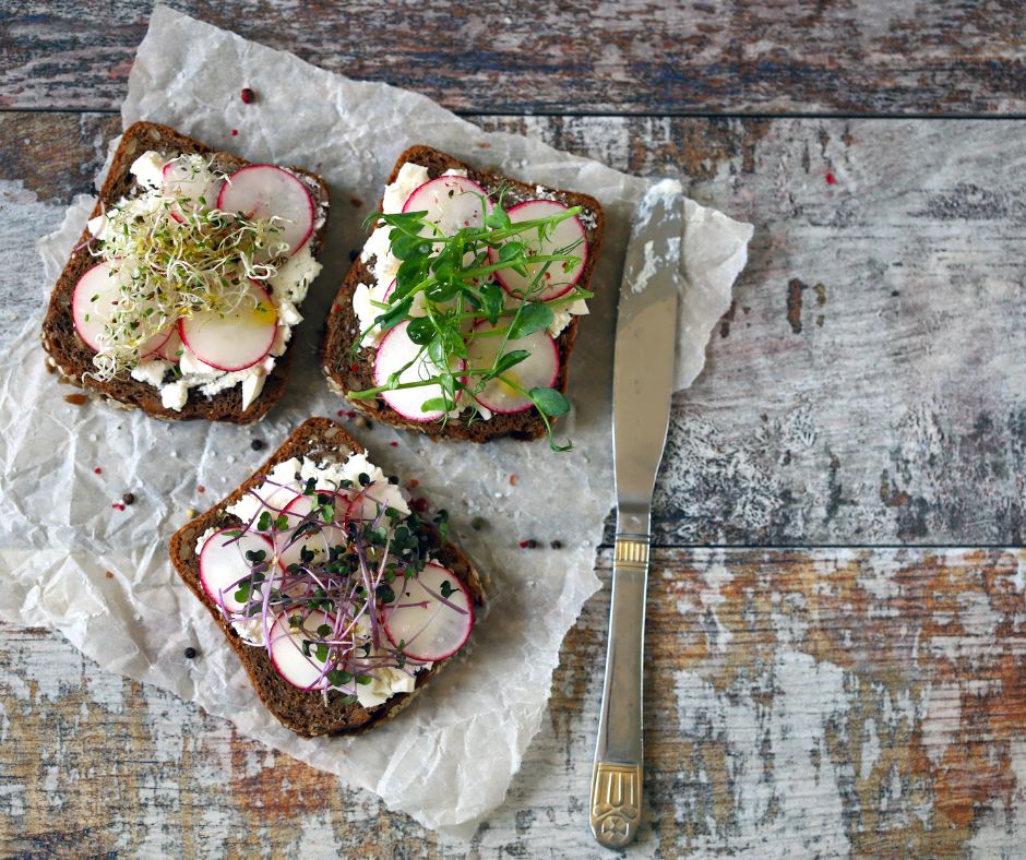Radish microgreens on toast with spread and fresh veggies.