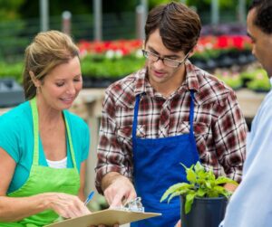 Staff at a garden center helping a customer review garden soil test results.