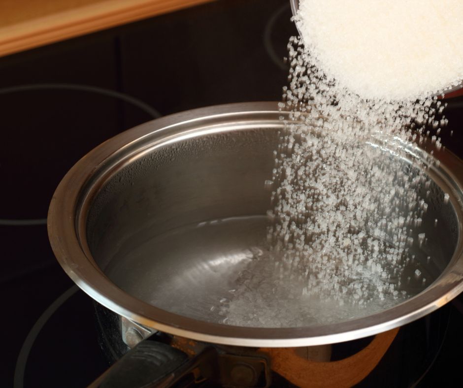 Making sugar water by adding white sugar to warm water for a feeder to attract hummingbirds to garden. 