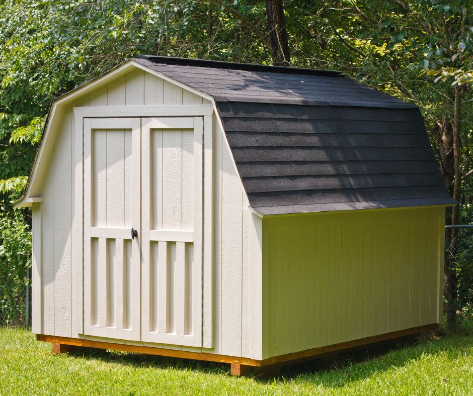 A large tan Dutch style garden shed with double doors and a grey shingled roof.