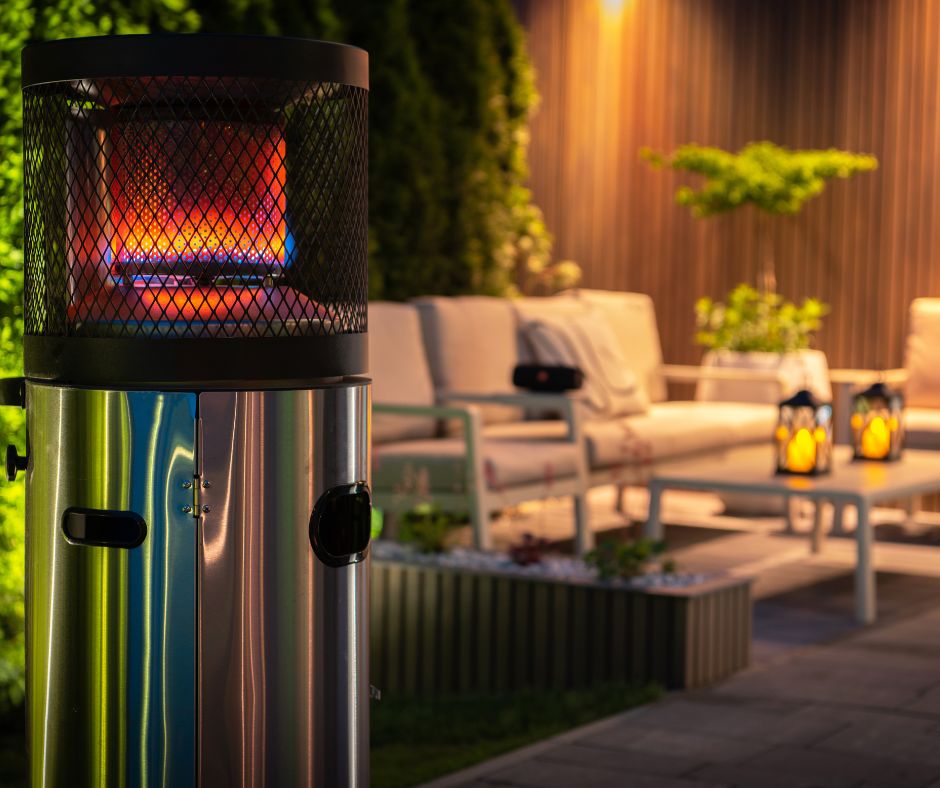Evening on a patio with a gas free standing outdoor heater, lounge chairs, and a living wall.