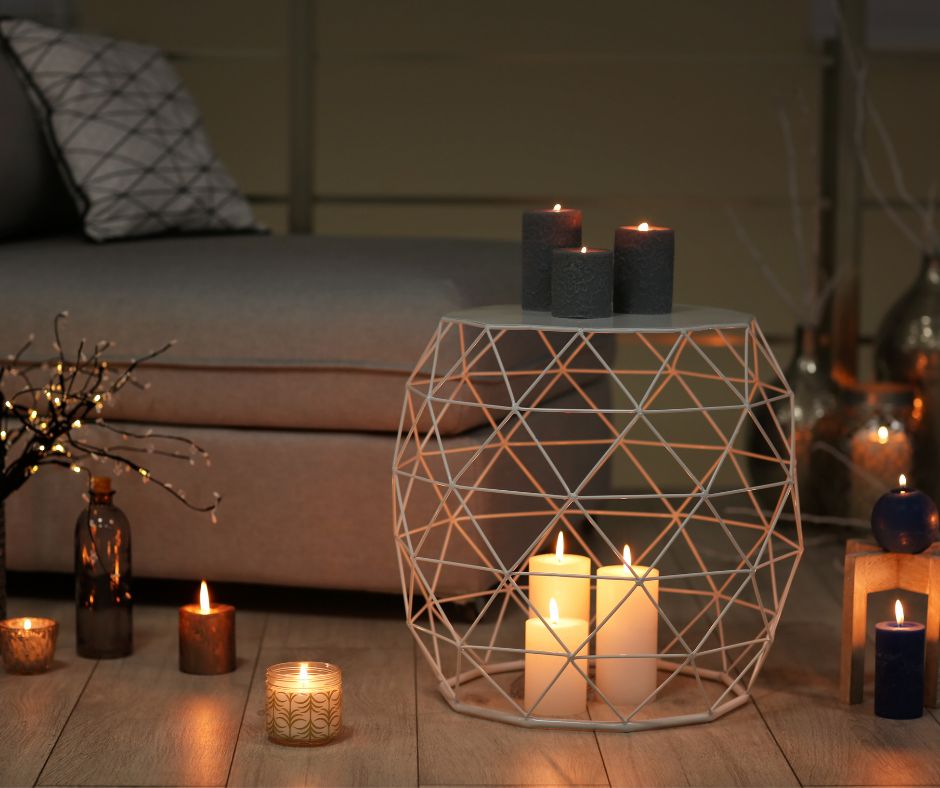Modern accessories for an outdoor reading nook. Candles and an open wire table on a light wood deck.