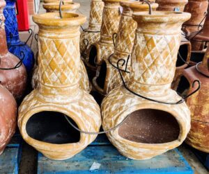 A selection of clay chimineas with decorative patterns. 