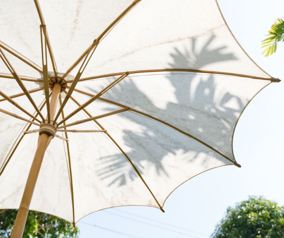 A white umbrella providing emergency shade in garden.