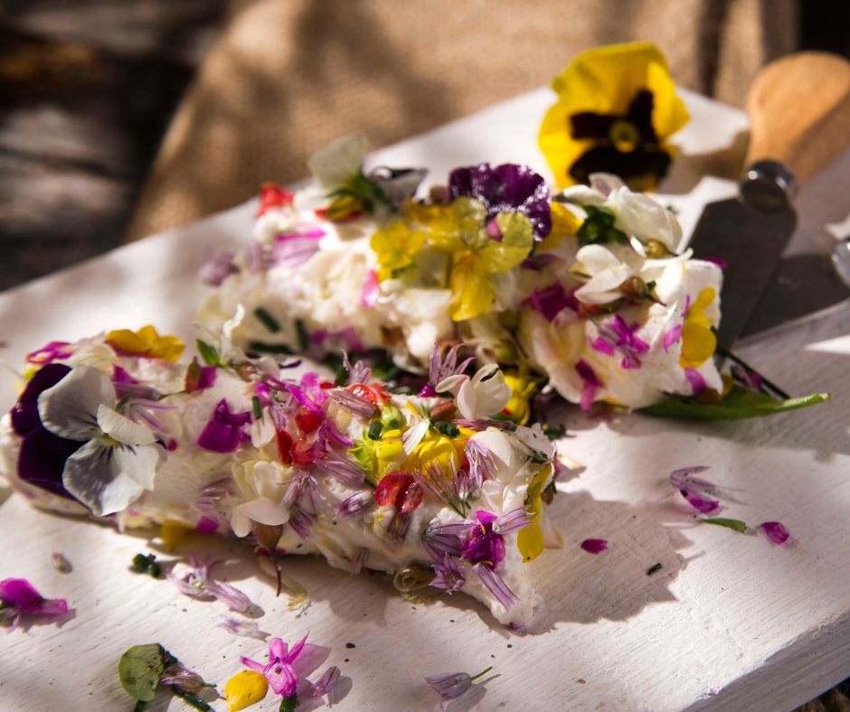 A soft cheese roll plate adorned in a variety of edible flowers.