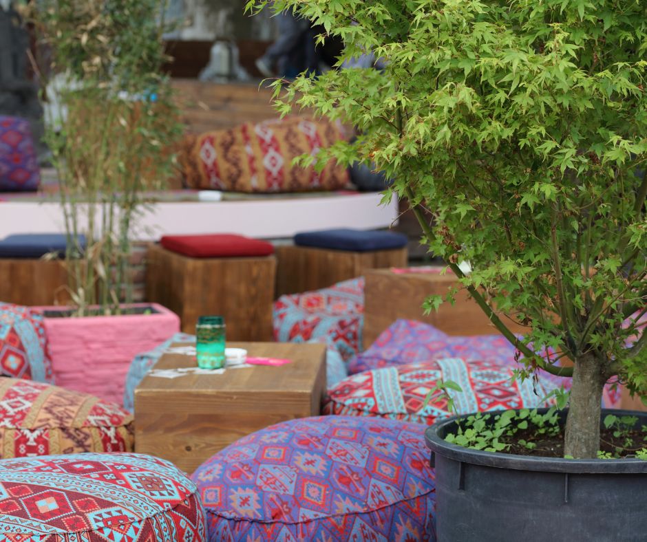 A bohemian style outdoor sitting area full of bright prints and comfortable seating.