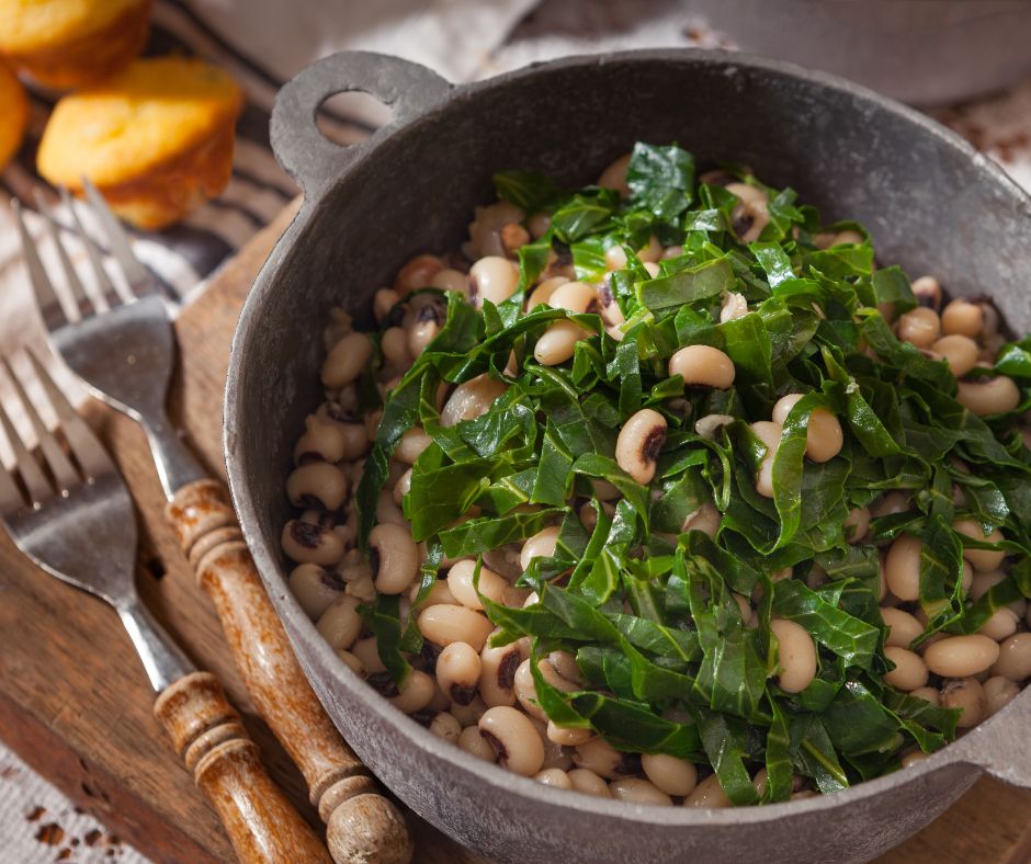 A bowl of blackeyed peas topped with shredded collard greens on a rustic table setting.