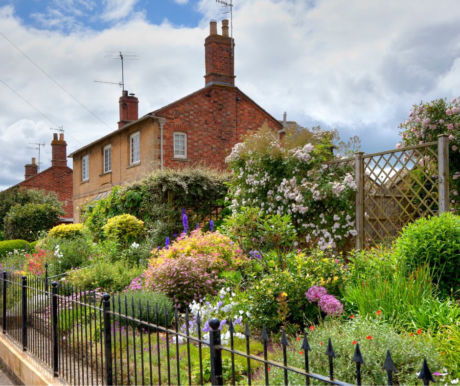 A front yard cottage garden with a variety of colorful plants in bloom.