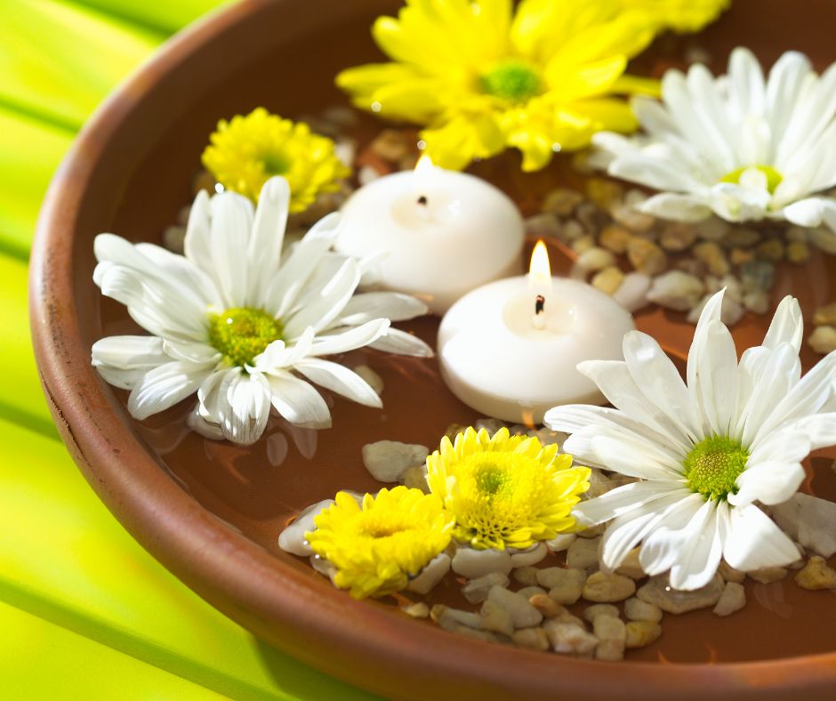 A floating candle and flower centerpiece featuring white and yellow daisies. 