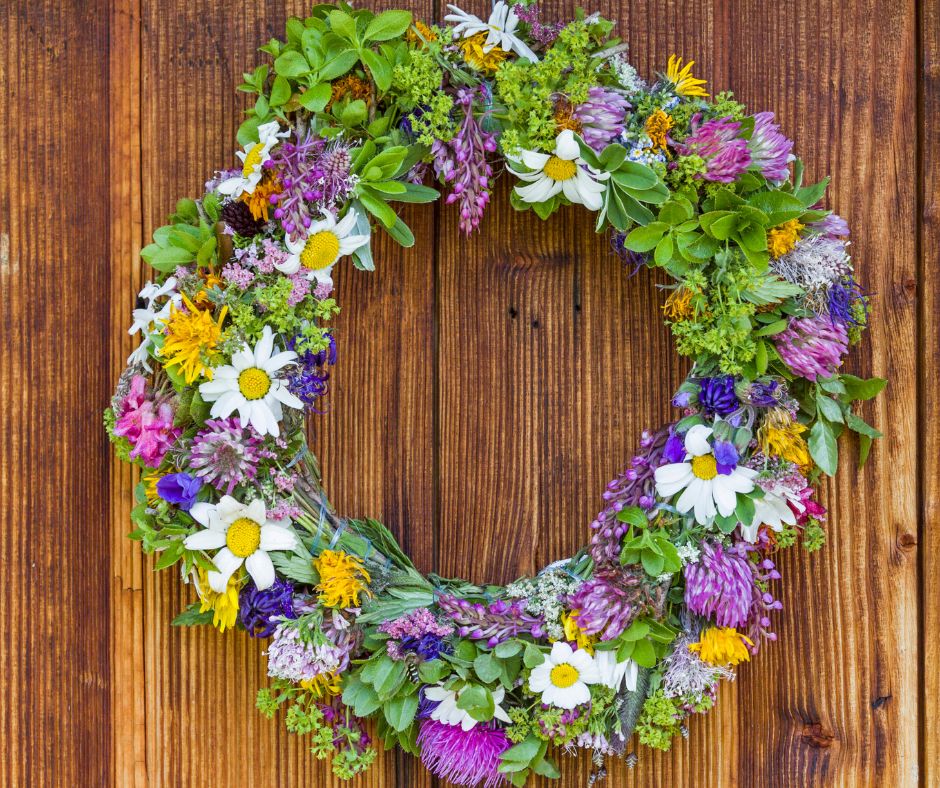 A door wreath make with colorful garden flowers and green leaves.