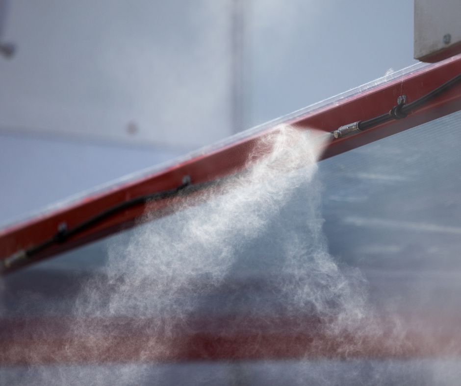 A patio misting system attached to a red beam.