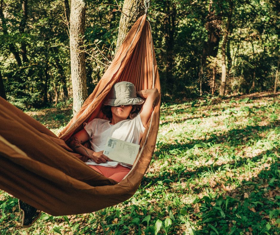 A woman reading a book in a hammock