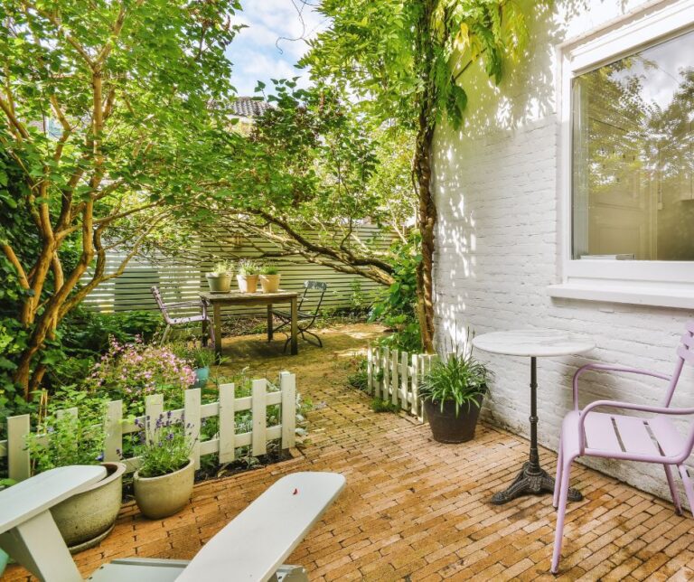 A small private enclosed yard with two sitting areas.