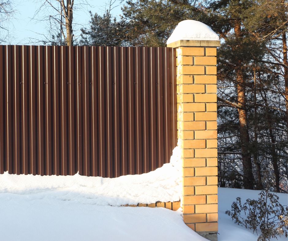Corrugated steel and stone fence.