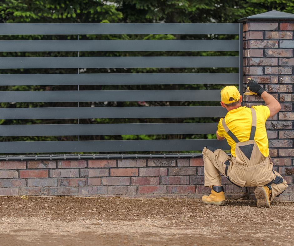 A man installing a new fence.