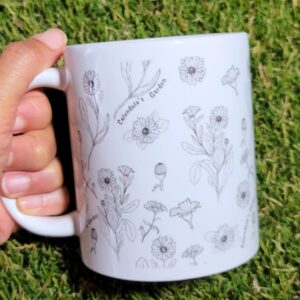 A garden mug with sketches of calendula flowers on it.