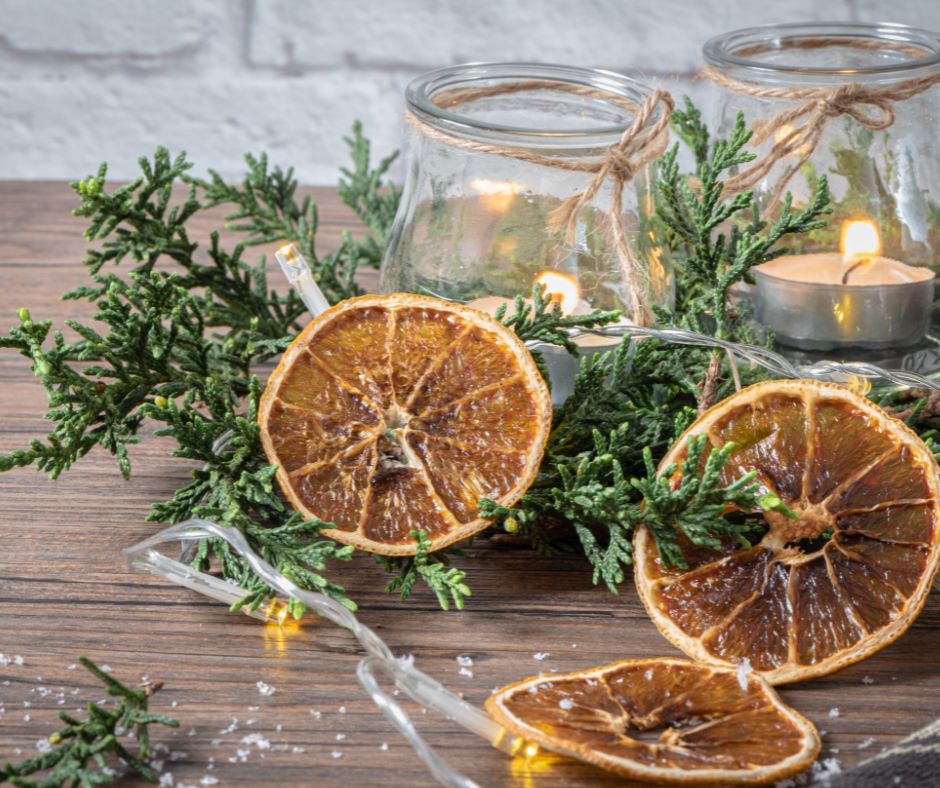 A naturally decoration center piece created with slices of dried citrus, evergreen foliage and candles.