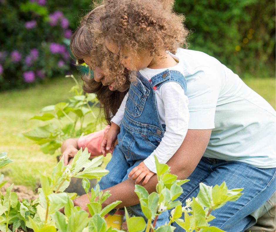 A woman and child tending to a vegetable garden.