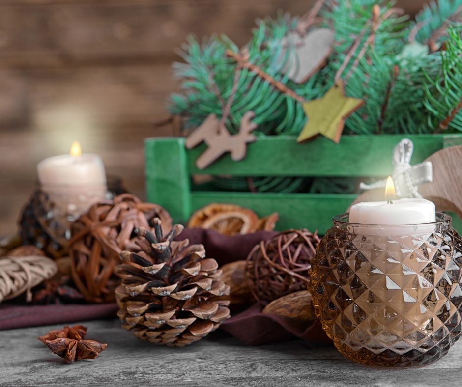 A table with dried grapevine balls,  pinecones, and candles in glass holders.