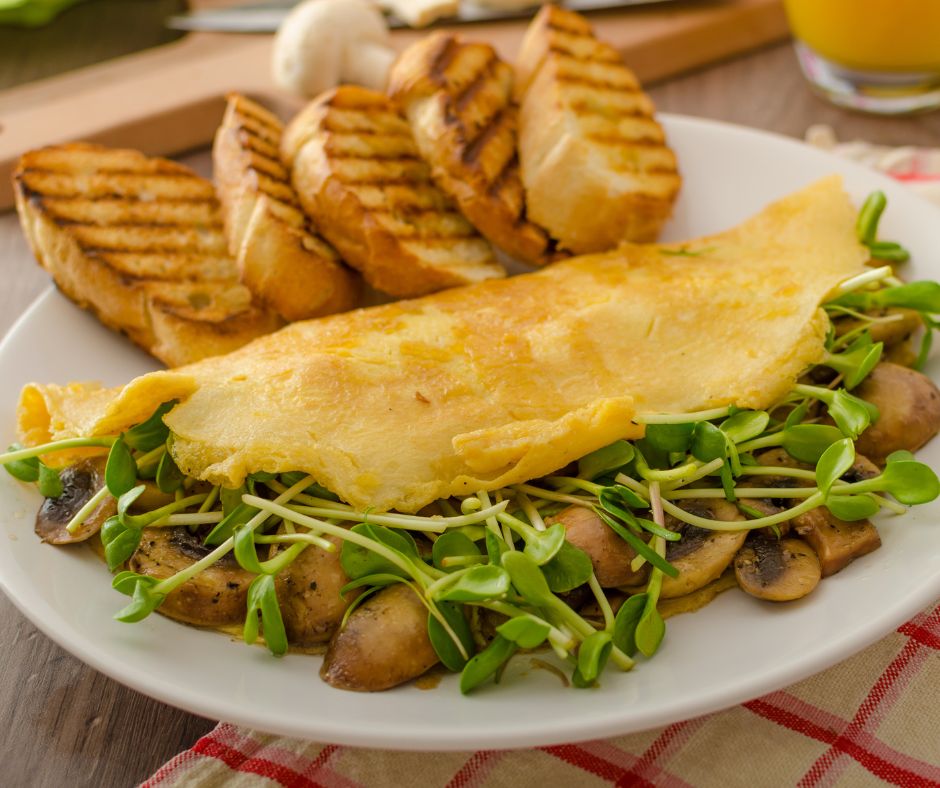 A plate with toast and a microgreen and mushroom omelet.