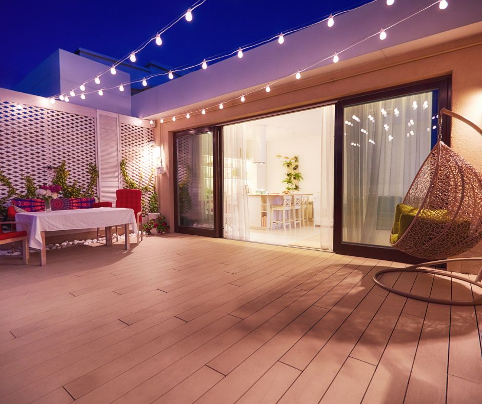 A deck that connect flush with the interior of a home through large sliding doors.
