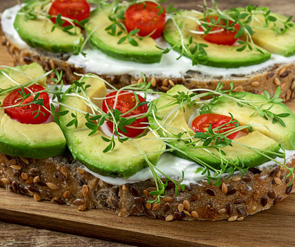 Elaborate avocado toast topped with tomatoes and microgreens.