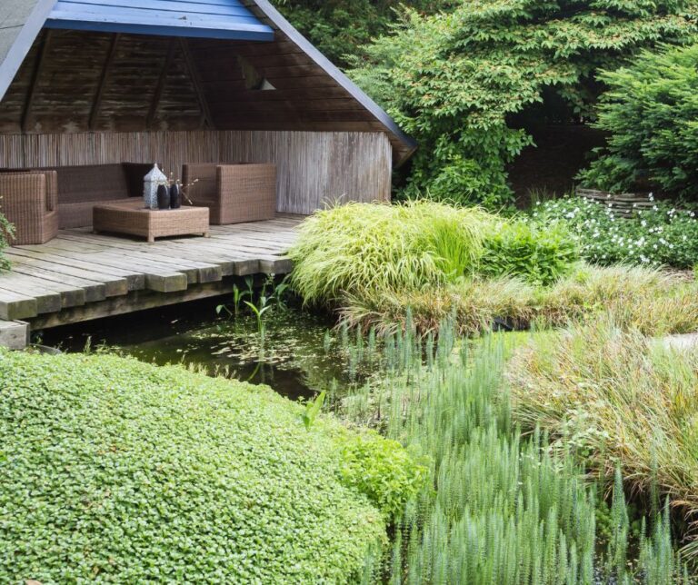 A lush private meditation garden with a streams and peace full covered sitting area.