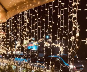 String lights obscuring a balcony street view.