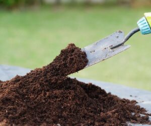 A garden trowel mixing soil.
