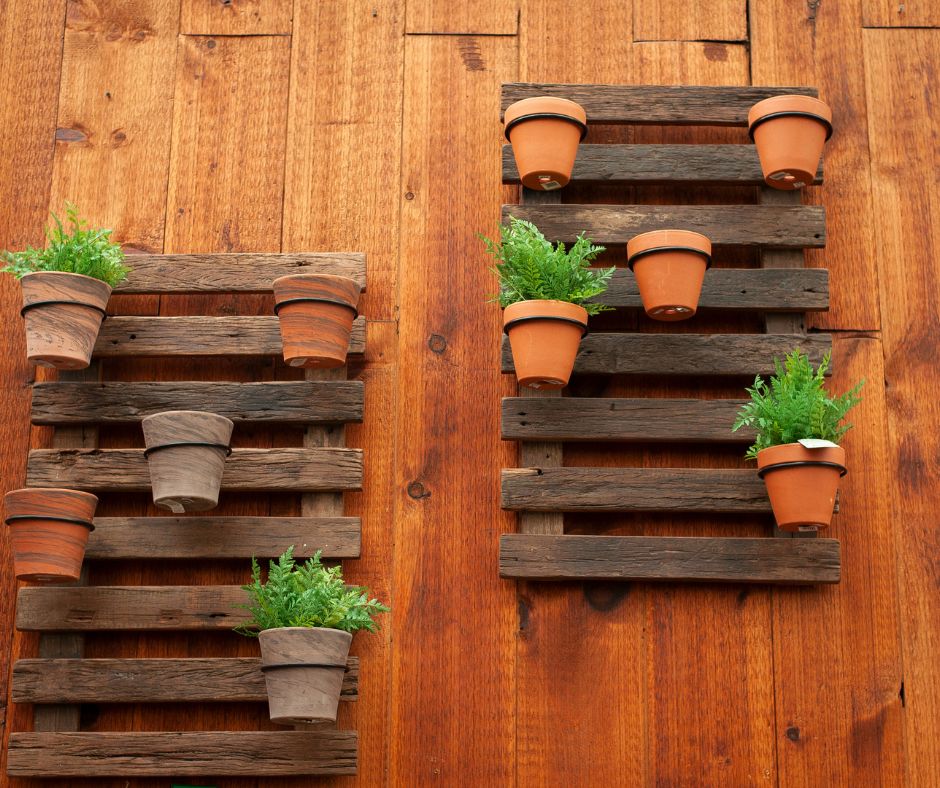 Wood pallet wall panels with plants in pots.