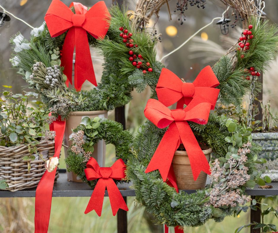 Large red bows on potted evergreens privacy screen.