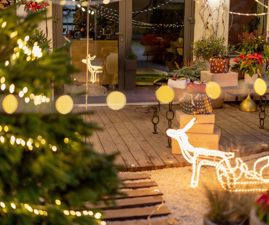 A deck and courtyard decorated with holiday lights.