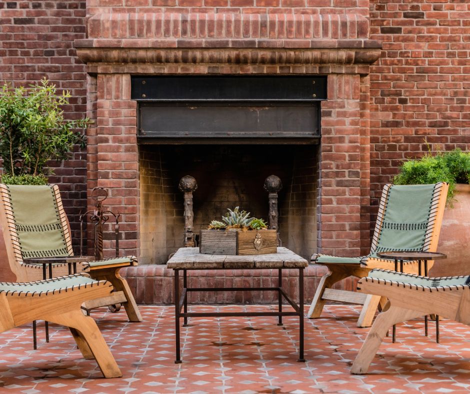 A seating area with a brick outdoor fireplace as the focal point.