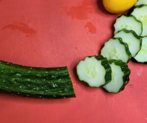 Suyo cucumber on a red cutting board.