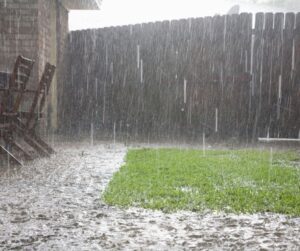 A severe rain storm causing a patio and backyard to flood.