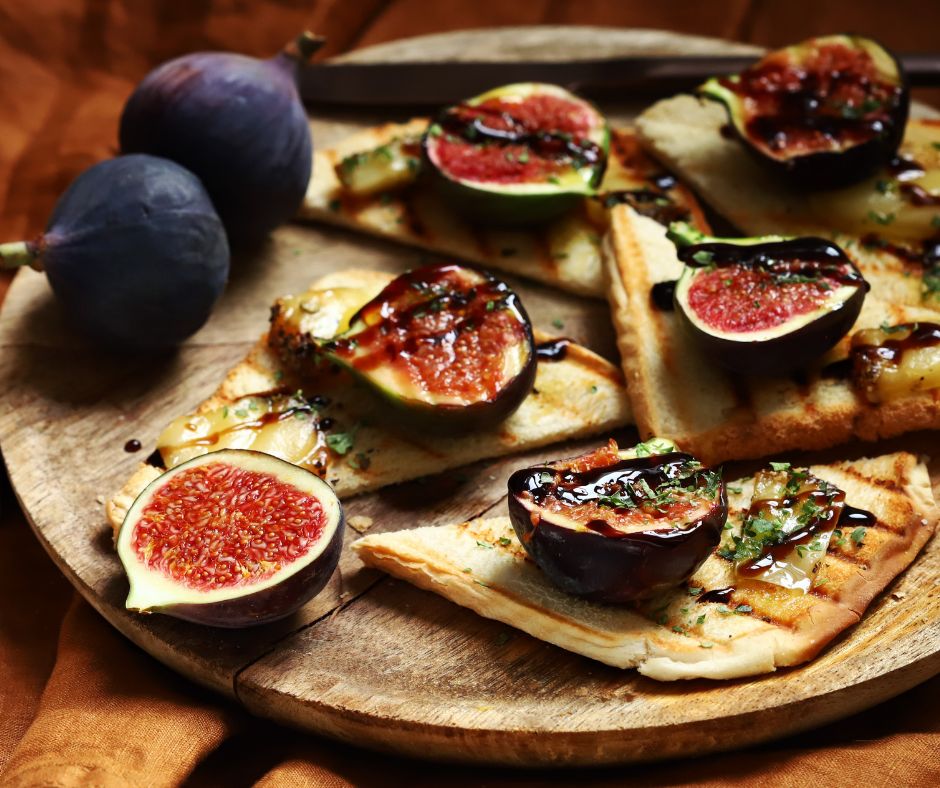A platter with grilled figs and pitas drizzled with balsamic sauce.