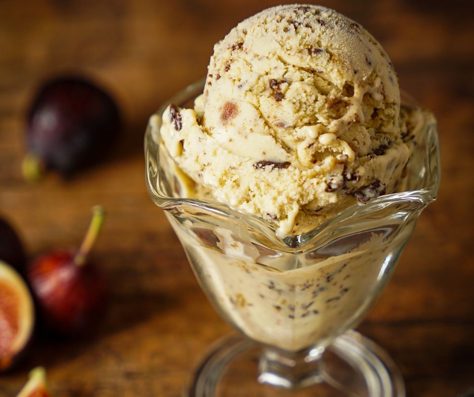 A glass dish with a couple of scoops of fig ice cream.