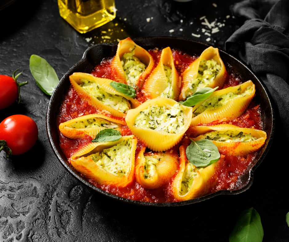 Basil Ricotta Stuffed Shells on red marinara sauce.
