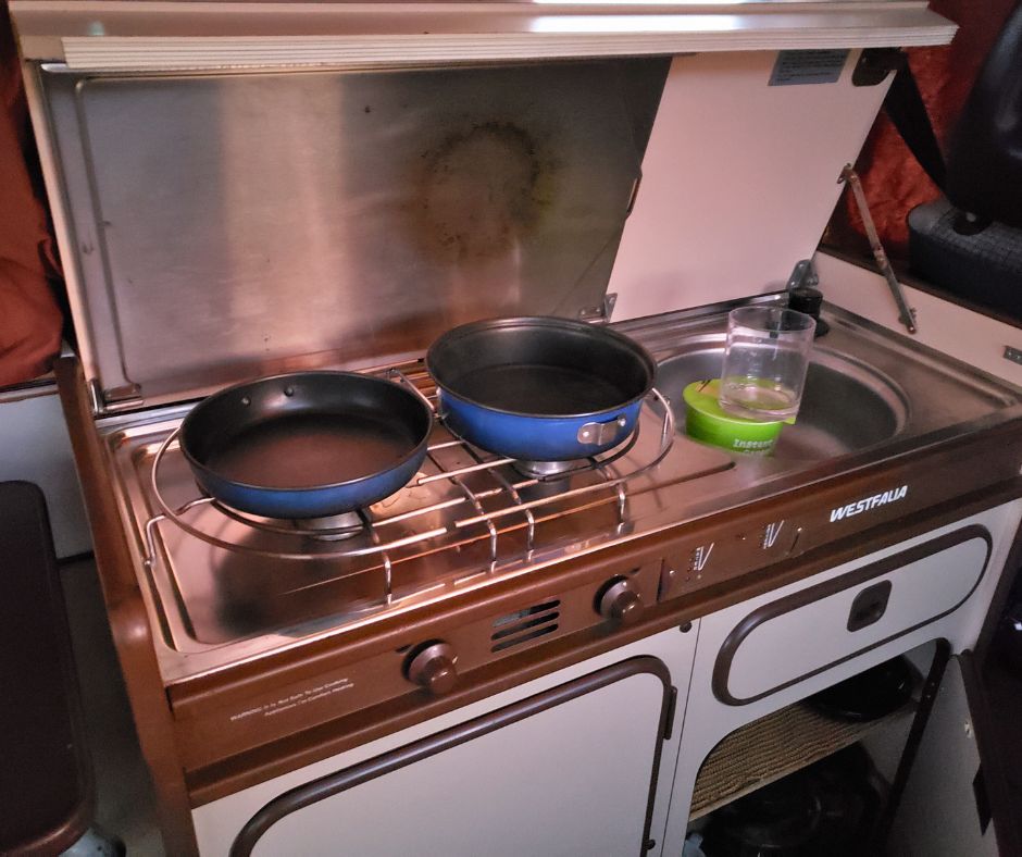 A camper van stove with pans.