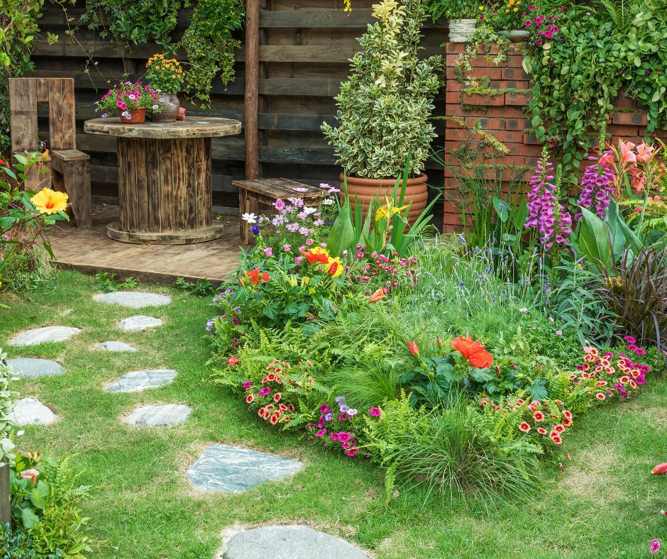 A simple wooden garden seating area surrounded by a lush flower garden.
